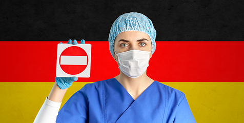 Image showing german doctor or nurse in mask showing stop sign