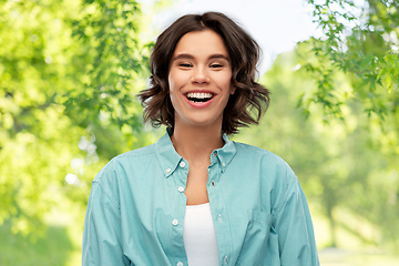 Image showing smiling young woman over green natural background