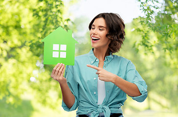 Image showing happy woman with green house on natural background