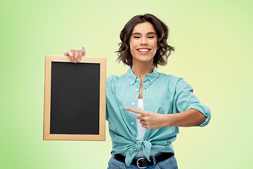 Image showing portrait of smiling woman showing black chalkboard
