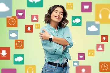 Image showing smiling woman with smart watch hugging herself