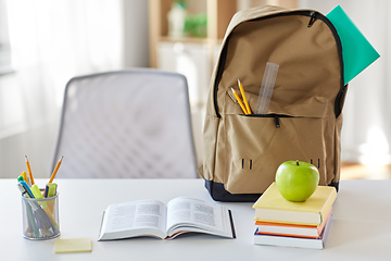 Image showing books, apple and school supplies on table at home