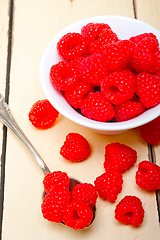 Image showing bunch of fresh raspberry on a bowl and white table