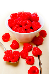 Image showing bunch of fresh raspberry on a bowl and white table