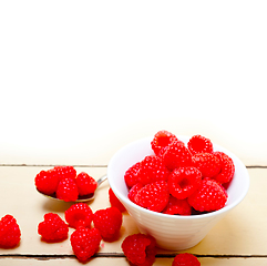 Image showing bunch of fresh raspberry on a bowl and white table