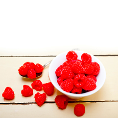 Image showing bunch of fresh raspberry on a bowl and white table