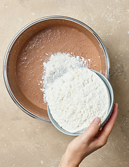 Image showing add flour to the bowl of chocolate cake dough