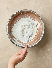 Image showing add flour to the bowl of chocolate cake dough