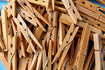 Image showing close up of wooden clothespins on blue background