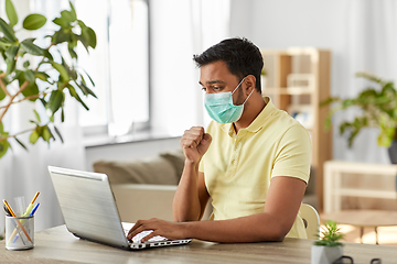 Image showing sick indian man in mask with laptop works at home