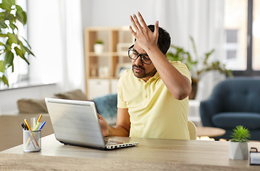 Image showing stressed man with laptop working at home office