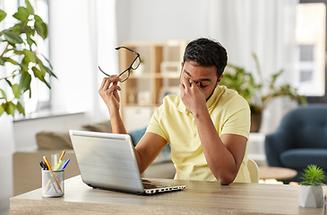 Image showing tired man with laptop working at home office