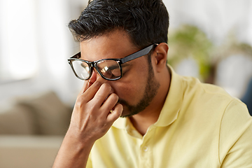 Image showing tired man rubbing his nose bridge at home