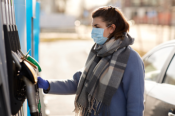 Image showing young woman wearing medical mask at gas station