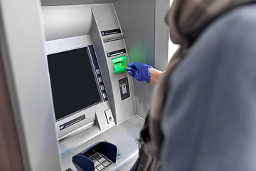 Image showing woman in medical glove with credit card at atm