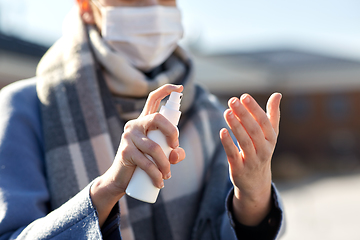 Image showing close up of woman spraying hand sanitizer