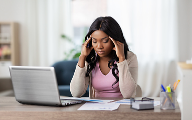 Image showing stressed woman with papers working at home office