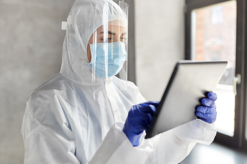 Image showing doctor in protective wear with tablet computer