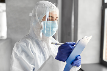 Image showing doctor in medical mask and shield with clipboard