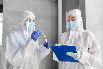 Image showing doctors in medical mask and shield with clipboard