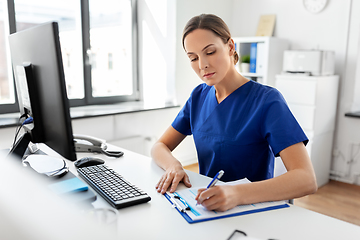 Image showing doctor or nurse with clipboard working at hospital