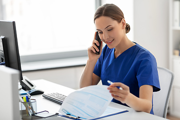 Image showing doctor with computer calling on phone at hospital