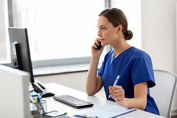 Image showing doctor with computer calling on phone at hospital