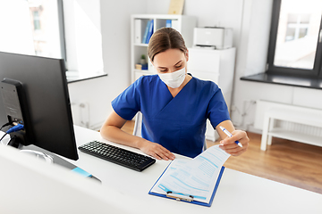 Image showing doctor or nurse in mask with clipboard at hospital