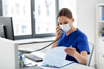 Image showing doctor with computer calling on phone at hospital