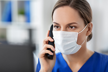 Image showing doctor with computer calling on phone at hospital