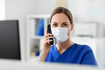 Image showing doctor with computer calling on phone at hospital