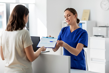 Image showing doctor with clipboard and patient at hospital