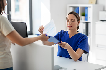 Image showing doctor with clipboard and patient at hospital