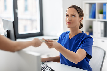 Image showing doctor and patient with credit card at hospital