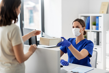 Image showing doctor offering mask to patient at hospital