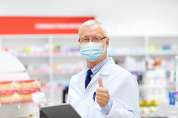 Image showing old apothecary in mask with tablet pc at pharmacy