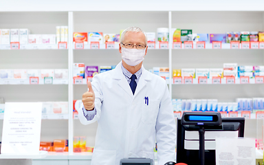 Image showing old apothecary in mask at pharmacy shows thumbs up