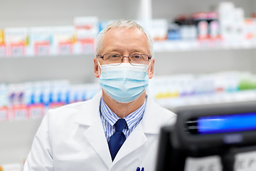 Image showing senior apothecary in mask at pharmacy