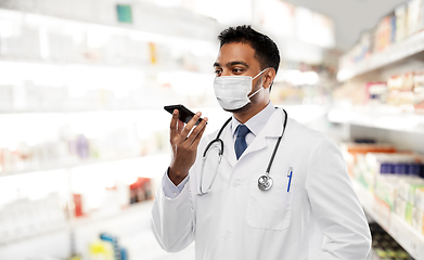 Image showing indian doctor in mask recording voice by cellphone