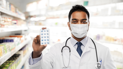 Image showing indian male doctor or pharmacist in mask with drug