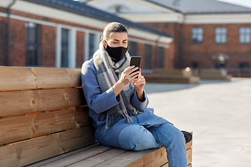 Image showing woman in face mask with smartphone in city