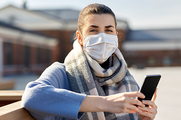 Image showing woman in face mask with smartphone in city