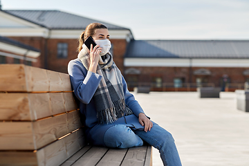 Image showing woman in face mask calling on smartphone in city