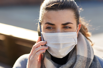 Image showing woman in face mask calling on smartphone in city