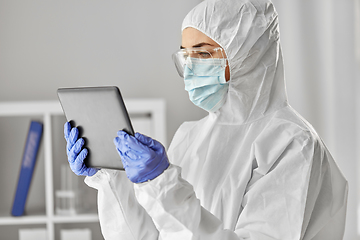 Image showing doctor in protective wear with tablet computer