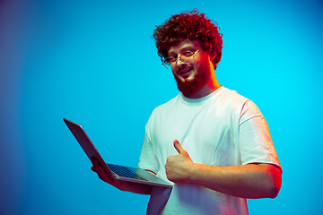 Image showing Caucasian man\'s portrait isolated on blue studio background in neon light