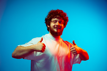 Image showing Caucasian man\'s portrait isolated on blue studio background in neon light