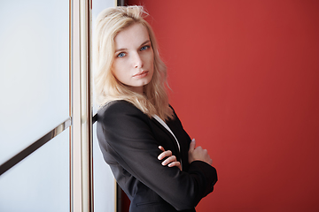 Image showing Young adult business woman standing next to the window