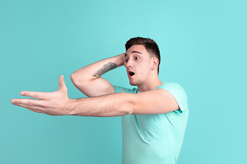 Image showing Caucasian young man\'s portrait on blue studio background