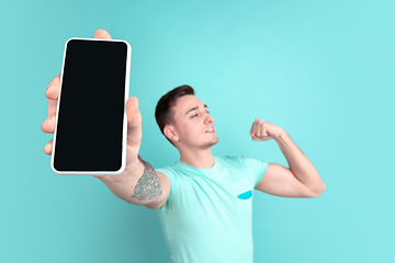 Image showing Caucasian young man\'s portrait on blue studio background